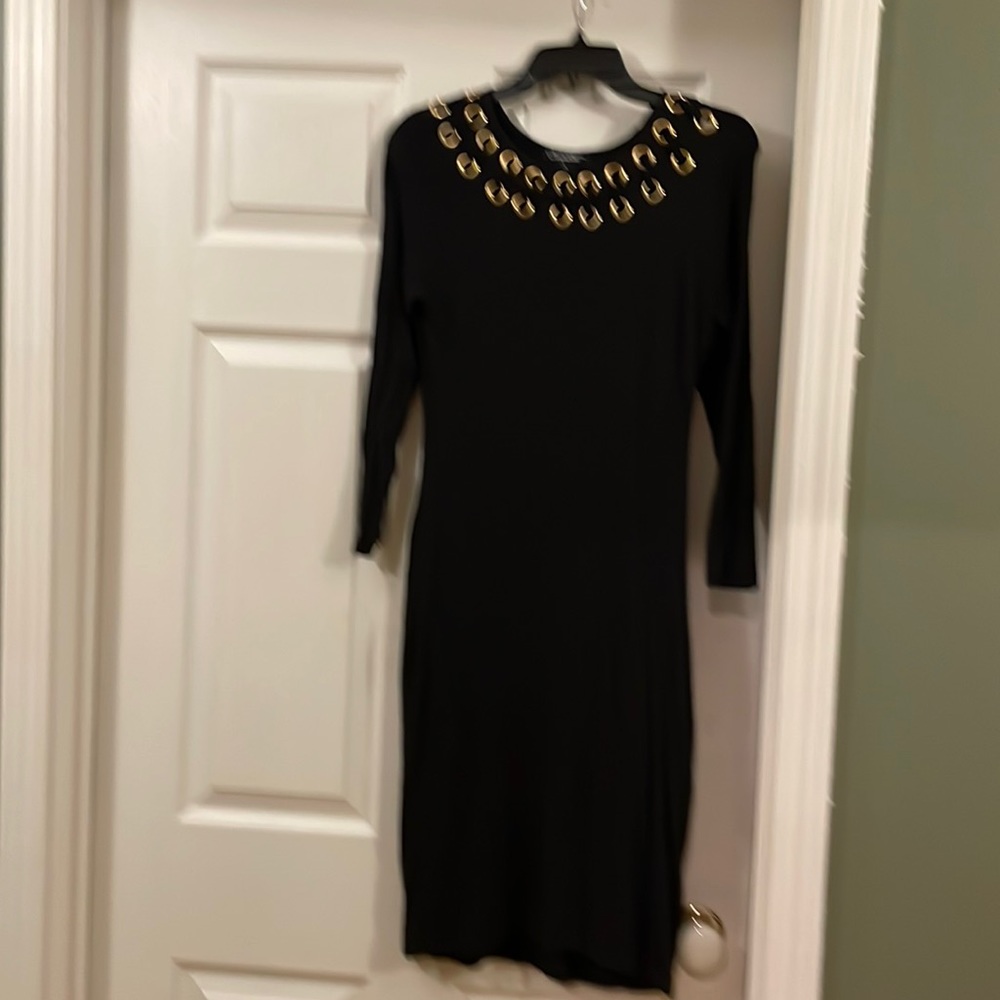Sexy, black dress accentuated with gold hoops.